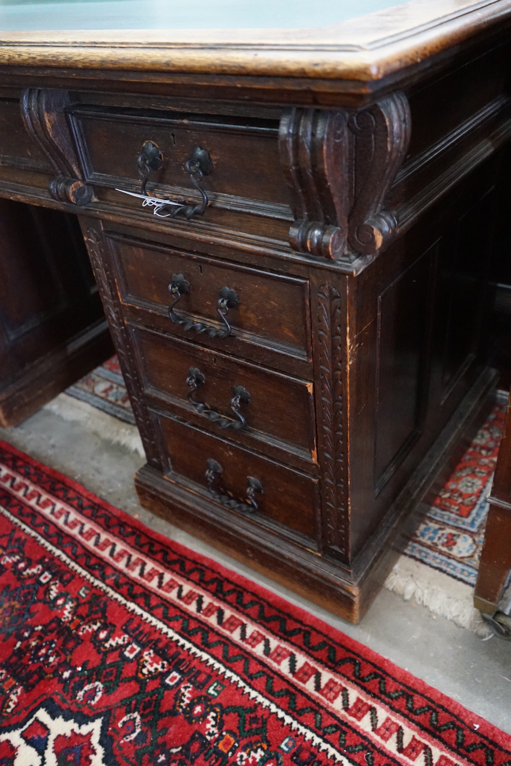 A late Victorian carved oak pedestal desk, length 137cm, depth 65cm, height 77cm